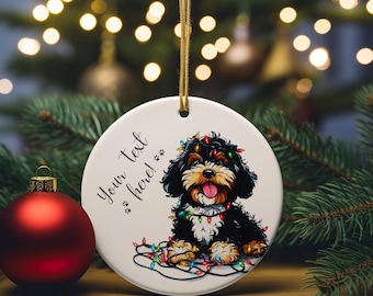 May include: A round, white Christmas ornament featuring a black and brown dog decorated with colorful Christmas lights. The ornament has the text "Your text here!" in black script. A red Christmas ball is in the foreground.