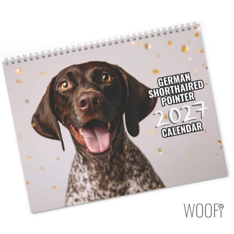 May include: A spiral-bound wall calendar featuring a portrait of a brown and white German Shorthaired Pointer with its tongue out. The cover includes the text GERMAN SHORTHAIRED POINTER 2027 CALENDAR against a light background with gold confetti.