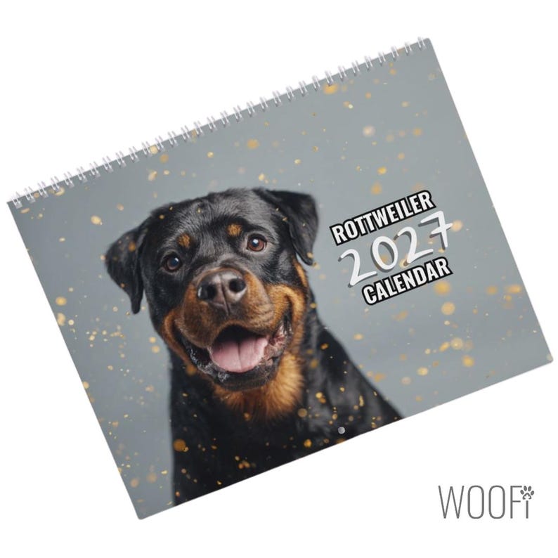 K&ouml;nnte beinhalten: Ein spiralgebundener Rottweiler-Kalender f&uuml;r 2027 mit dem Portr&auml;t eines schwarz-braunen Rottweilers mit offenem Maul auf grauem Hintergrund mit goldenen Sprenkeln. Der Text auf dem Cover lautet ROTTWEILER 2027 CALENDAR in wei&szlig;er und schwarzer Schrift.