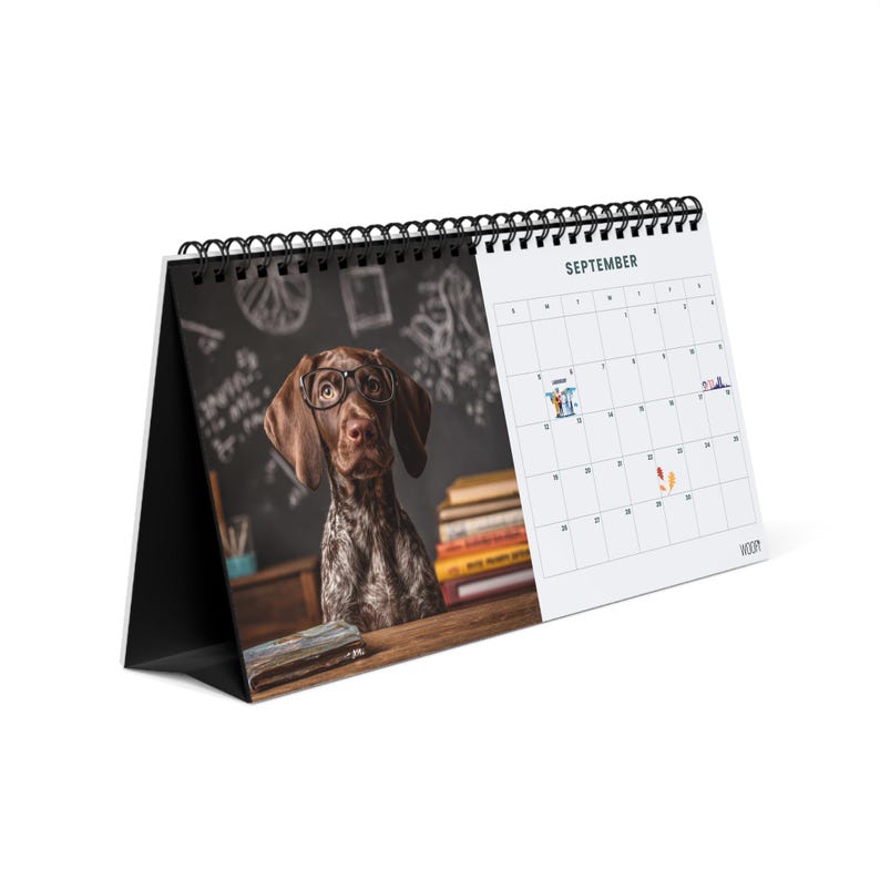 May include: A desk calendar with a black spiral binding featuring a photograph of a brown and white dog wearing glasses in front of a chalkboard with books. The right side displays the month of September with a grid and small icons on specific dates.