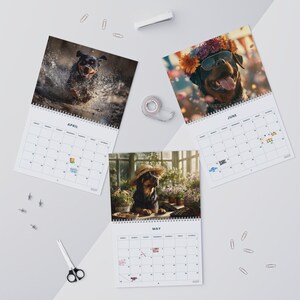 K&ouml;nnte beinhalten: Drei spiralgebundene Wandkalender mit Rottweiler-Hunden. Das April-Blatt zeigt einen Hund beim Planschen im Wasser, Mai einen Hund in einem Gew&auml;chshaus mit Strohhut und Juni einen Hund mit Sonnenbrille und einem bunten Blumenkranz.
