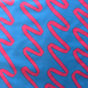 Peut inclure: Gros plan sur un tissu avec un motif répétitif de lignes ondulées rose vif sur un fond bleu vibrant. Les lignes sont épaisses et créent un design audacieux et accrocheur. Le tissu semble lisse.
