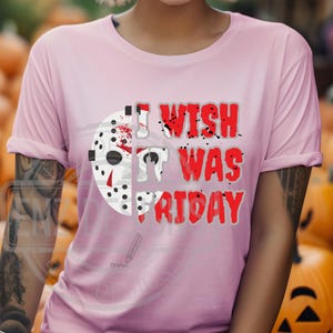 K&ouml;nnte beinhalten: Rosa T-Shirt mit einem Grafikdruck eines Hockey-Masks und dem Text "I wish it was Friday".