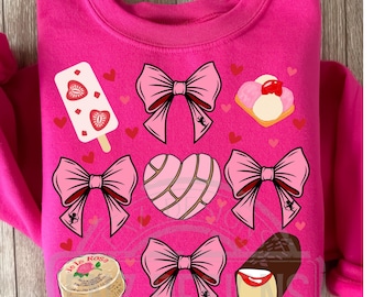May include: Pink sweatshirt with a variety of pink and red images including hearts, bows, and Mexican pastries. The text "Je la Rosa" is on a pink and white pastry.