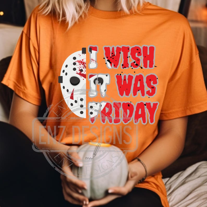K&ouml;nnte beinhalten: Orangefarbenes T-Shirt mit einem Grafikdruck eines Hockey-Masks mit Blutspritzern und dem Text "I wish it was Friday".