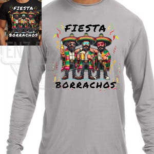 May include: A gray long-sleeve shirt featuring a graphic of three cartoon figures in sombreros, holding drinks. The text "FIESTA" and "BORRACHOS" are above and below the figures, respectively. The figures are wearing colorful serapes.
