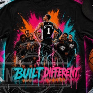 Pode incluir: Camiseta preta com um jogador de basquete, o nome "Wembanyama" e o número 1. O design inclui o texto "IN BUILT DIFFERENT" e outros jogadores. O fundo tem um efeito de grafite colorido. Uma bola de basquete é visível.
