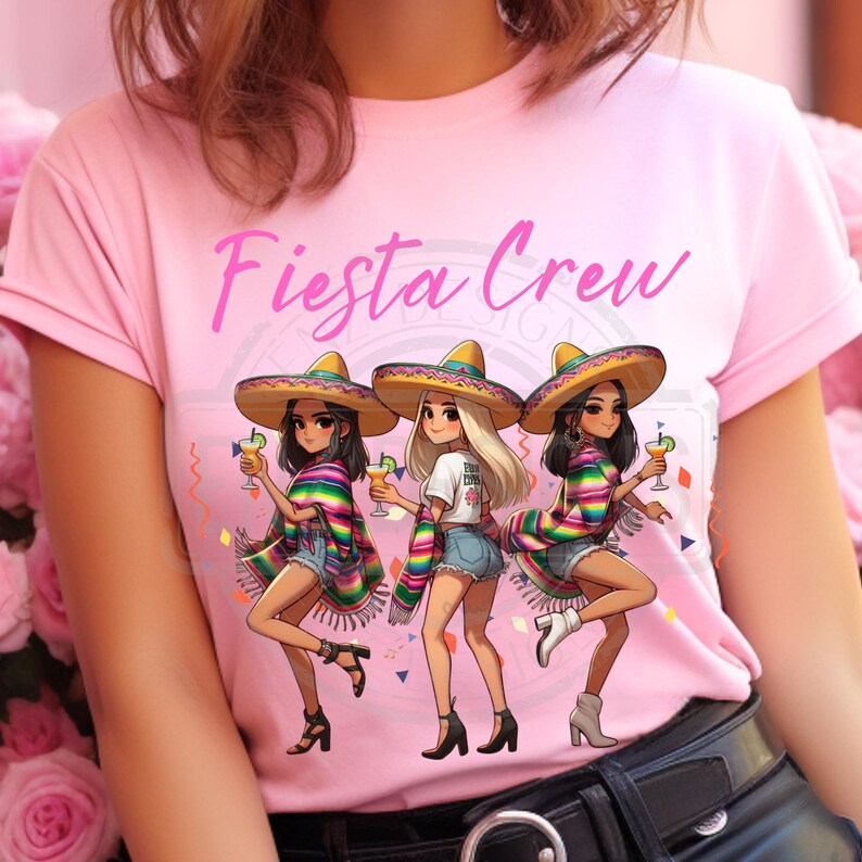 May include: Pink t-shirt with the text "Fiesta Crew" in cursive. The graphic features three cartoon women wearing sombreros, ponchos, and denim shorts, holding cocktails. Colorful confetti and streamers are also in the design.
