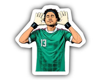 May include: A die-cut sticker featuring a cartoon illustration of a soccer goalkeeper with curly hair and a headband. The figure wears a green jersey with the number 13, black wristbands, and cream-colored goalkeeper gloves held near the ears.