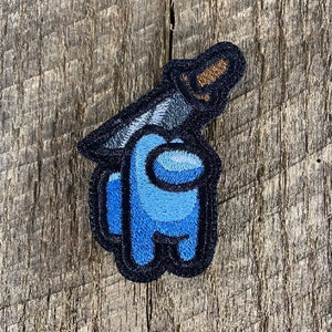Puede incluir: Parche azul bordado de un personaje de Among Us con un cuchillo que le sale de la cabeza.