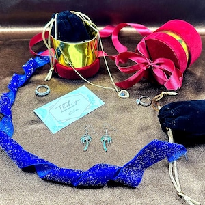 May include: A gift box set with a red velvet box, a gold box, a blue velvet ribbon, a necklace with a heart pendant, a pair of palm tree earrings, a ring, and a card that says "Thank you for your purchase".