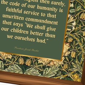 May include: A framed print featuring a quote by President Josiah Bartlet on a green background with gold trim. The quote reads, "We shall give our children better than we ourselves had." The frame has a brown wood finish and a floral pattern.