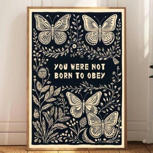 May include: Black and white print with the text "You were not born to obey" surrounded by stylized butterflies and floral designs.