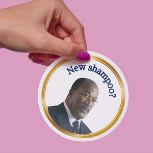 May include: A circular sticker featuring a gold border and the text New shampoo? in dark blue. The center displays a photographic portrait of a man with a mustache wearing glasses, a white collared shirt, a dark tie, and a dark suit jacket.