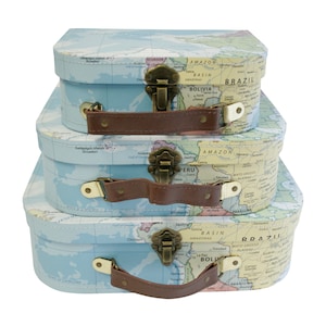 May include: Three blue and white cardboard suitcases with brown leather handles and gold metal clasps. Each suitcase features a world map design with country names and geographical features.
