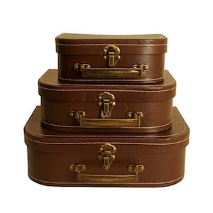 May include: Three brown suitcases with brass handles and latches. The suitcases are stacked on top of each other, with the largest suitcase on the bottom and the smallest suitcase on top.