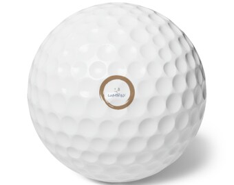 May include: White golf ball with a brown circle sticker that says "Lumbini" in blue text.