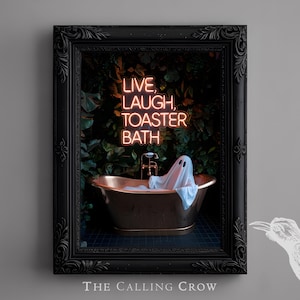 May include: Framed art print featuring a vintage-style bathtub with a ghost figure. The artwork includes the neon text "LIVE, LAUGH, TOASTER, BATH" against a backdrop of lush greenery. The frame is black and ornate, with the text "THE CALLING CROW" at the bottom.