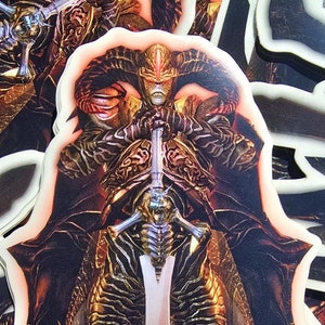 May include: A sticker featuring a detailed illustration of a dark figure in armor holding a large sword. The figure has horns and a crown, and the sword is decorated with intricate details. The sticker is printed on a glossy, white background.