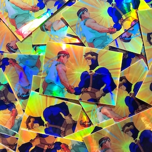 May include: A holographic sticker featuring two characters from a video game. The characters are shaking hands, one is wearing a blue and black suit and the other is wearing a blue and white suit. The sticker has a rainbow iridescent background.