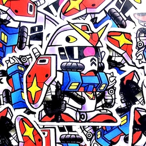 May include: A die-cut sticker featuring a chibi-style robot character with a white, red, and blue color scheme. The robot has a yellow V-fin on its head, a red shield with a yellow star emblem, and blue arm segments. The design is outlined in black.