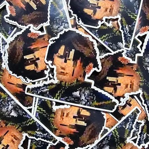 Puede incluir: Una pila de pegatinas pixeladas con un personaje de dibujos animados con cabello castaño y un atuendo negro y verde. Las pegatinas están impresas en papel blanco con un contorno negro.