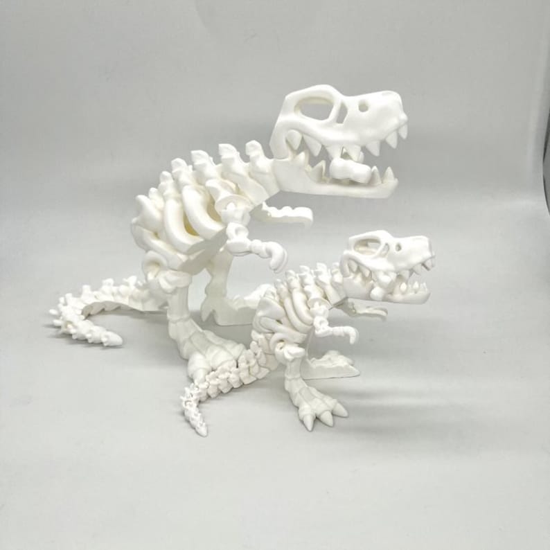 May include: Two white plastic dinosaur skeletons, one larger than the other, posed in a playful manner. The larger dinosaur is standing on its hind legs with its tail curled around the smaller dinosaur's body. The smaller dinosaur is standing on all fours with its head tilted to the side.
