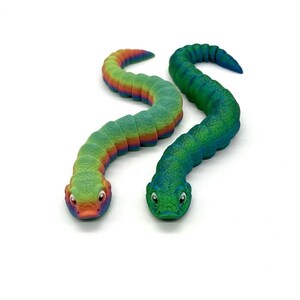 May include: Two colorful, flexible, plastic toy snakes. One snake is green and blue, the other is rainbow colored.