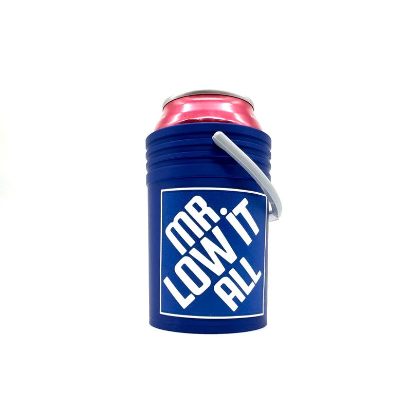 Puede incluir: Un enfriador de latas azul con una etiqueta blanca que dice "MR. LOW IT ALL". Tiene un asa gris y sostiene una lata rosa.