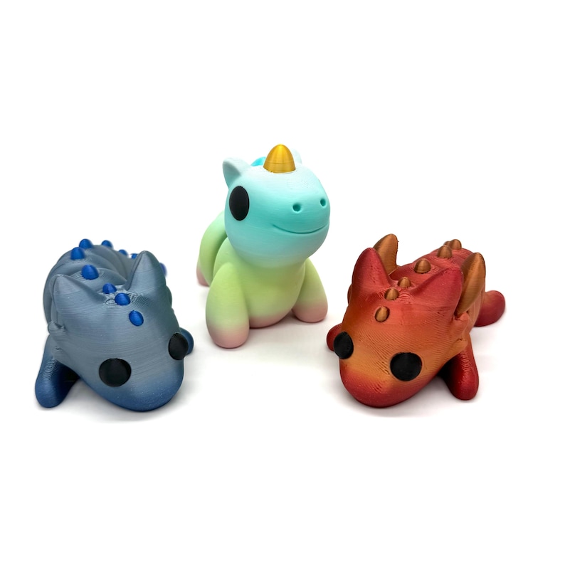 May include: Three small, hand-painted figurines: a blue and grey dragon, a green and blue unicorn, and a red and orange dragon.