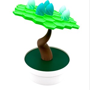 May include: A whimsical, 3D-printed decorative tree. It features a bright green, hexagonal canopy with several teal and white bud-like structures. The brown trunk curves upwards from a dark green base, set in a white pot.
