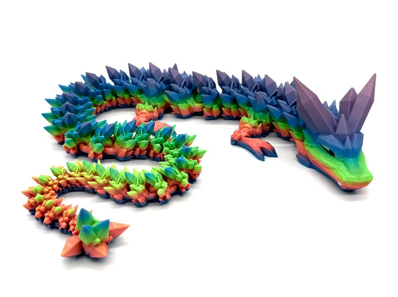 May include: A rainbow-colored dragon figurine with a crystal-like texture. The dragon is curled up in a serpentine shape with its head raised.