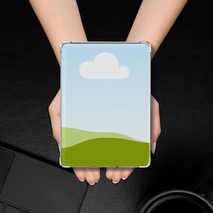 May include: A phone case with a green field, blue sky, and a white cloud design.