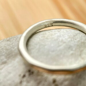 May include: A silver band ring with a 925 stamp on the inside.