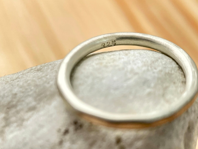 May include: A silver band ring with a 925 stamp on the inside.