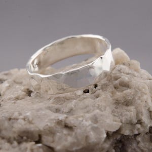 Op de afbeelding: Een zilveren gehammerde ring met een textuur.