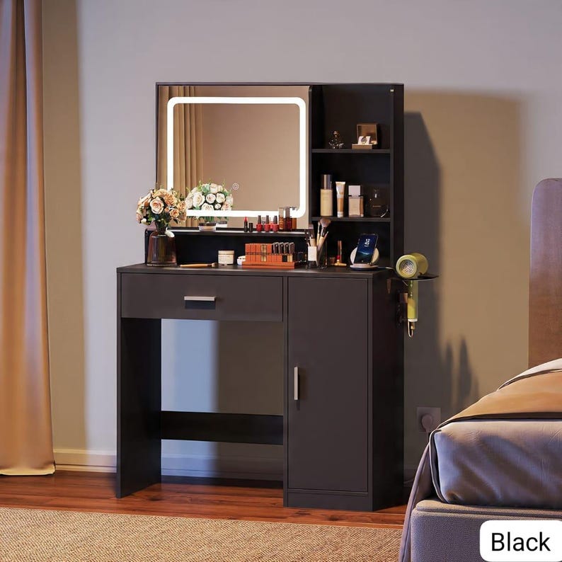 May include: Black vanity with a lighted mirror, drawer, and cabinet. The vanity has a shelf with beauty products and a hairdryer holder. A bouquet of flowers sits on the vanity top. The word "Black" is in the bottom right corner.