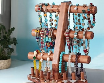May include: A wooden jewelry display stand with multiple levels for necklaces and bracelets. The stand is filled with colorful beaded jewelry and rings. The base of the stand has slots for rings. The word "Wood" is in the bottom right corner.