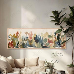 May include: A long, rectangular canvas art piece featuring an abstract floral design in a variety of colors, including red, blue, and yellow. The artwork is framed in a light brown wooden frame. The text "POPLART DESIGN" is visible in the bottom right corner.