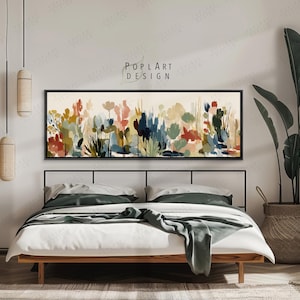 May include: A bedroom scene featuring a bed with white linens and a green throw. Above the bed is a long, rectangular framed artwork with a colorful floral watercolor design. The artwork is labeled "POPLART DESIGN". A large potted plant and decorative lighting complete the room.