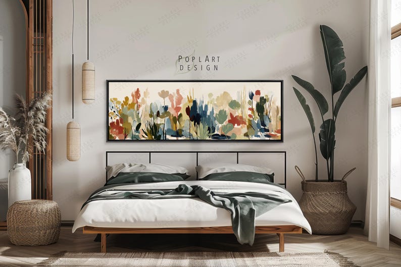 May include: A bedroom scene featuring a bed with white linens and a green throw. Above the bed is a long, rectangular framed artwork with a colorful floral watercolor design. The artwork is labeled "POPLART DESIGN". A large potted plant and decorative lighting complete the room.