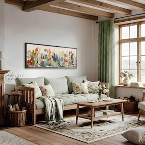 May include: A living room scene featuring a wooden framed floral painting above a light green sofa with floral pillows. A wooden coffee table and a patterned rug complete the cozy, inviting space. A green curtain and a window with natural light are also visible.
