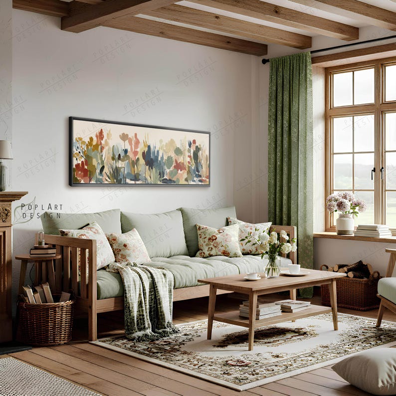 May include: A living room scene featuring a wooden framed floral painting above a light green sofa with floral pillows. A wooden coffee table and a patterned rug complete the cozy, inviting space. A green curtain and a window with natural light are also visible.