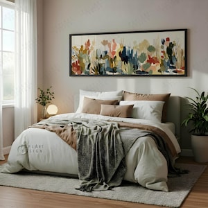 May include: A bedroom scene featuring a bed with white bedding, brown pillows, and a gray blanket. A large floral painting hangs above the bed. A potted plant sits on the right side of the bed.