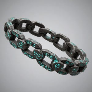 May include: A dark gray chain bracelet with teal-colored inscriptions. The bracelet is made of interlocking links, each bearing etched symbols. The overall design suggests a weathered, ancient aesthetic, suitable for cosplay or themed jewelry.