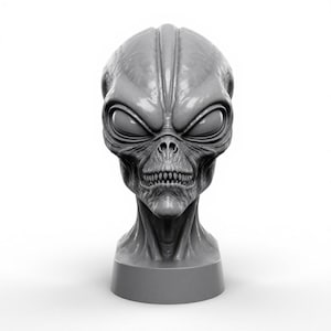 Puede incluir: Una escultura de cabeza alienígena gris con ojos grandes y oscuros, una frente prominente y una cara detallada con aspecto de esqueleto. La escultura está montada sobre una base gris, y el diseño general es detallado y realista.