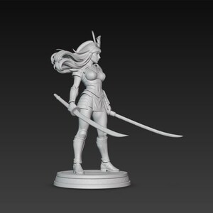 May include: A detailed, monochromatic figurine of a female warrior, clad in armor and holding two curved swords. The figure has long flowing hair and stands on a circular base. The overall design suggests a fantasy or historical theme.