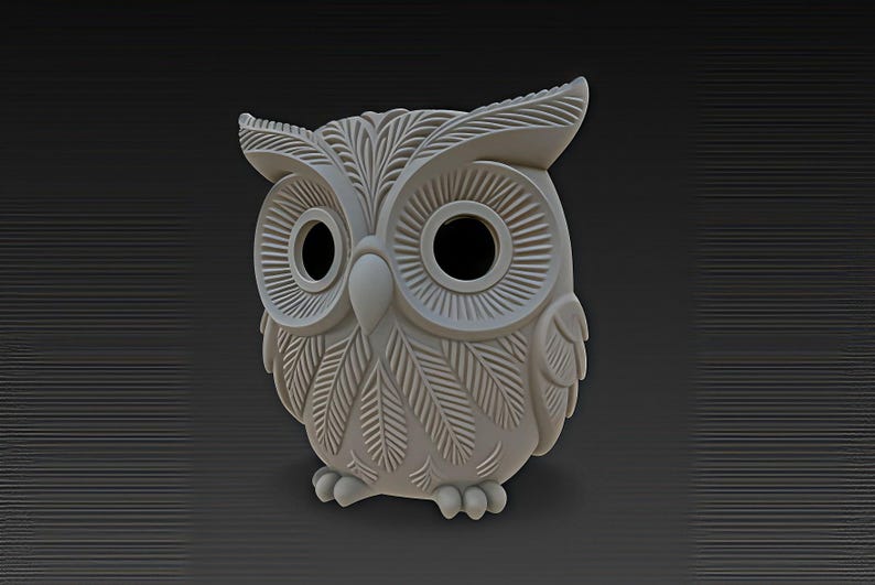 May include: A light gray owl figurine with detailed feather and eye designs. The owl has large, round eyes and a beak. The figurine is made of a solid material and has a textured surface. The owl is a decorative item.