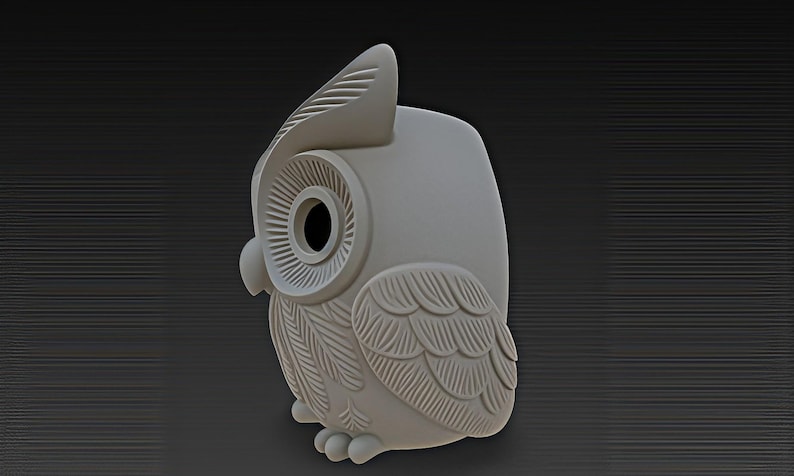 May include: A light gray owl figurine with detailed feather and eye designs. The owl has a large head with a prominent beak and large, round eyes. The figurine is a decorative item.