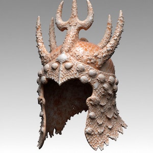 Op de afbeelding: Een gedetailleerde, getextureerde helm in tinten beige en crème, versierd met schelpen en een drietandvormige kam. De helm heeft een schubachtig ontwerp aan de onderkant en is waarschijnlijk een kostuumstuk of decoratief item.